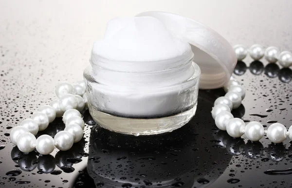 Crema cosmética en la mesa sobre fondo gris — Foto de Stock