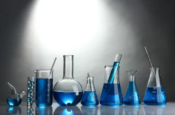 회색 배경에 파란색 액체와 시험관 — 스톡 사진