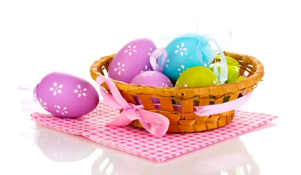 Huevos coloridos de Pascua en cesta en servilleta aislada en blanco — Foto de Stock