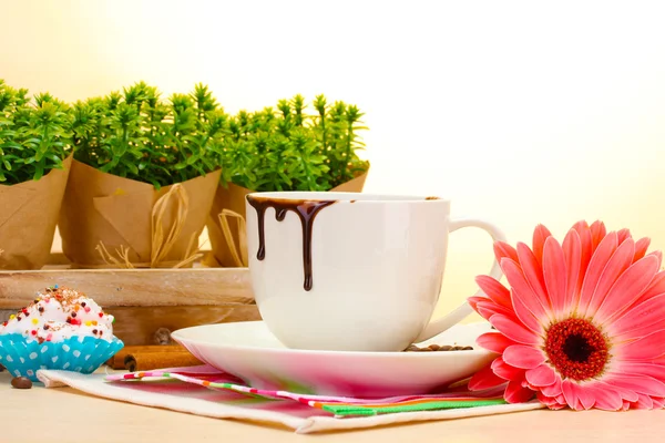 Taza sucia de café y granos de gerberas, palitos de canela en la mesa de madera —  Fotos de Stock