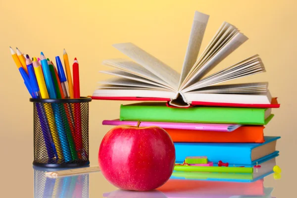 Komposisi buku, alat tulis dan apel pada latar belakang cerah berwarna-warni — Stok Foto