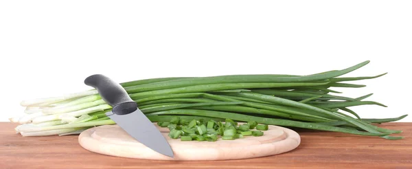 Cebola verde em uma tábua de corte com faca em madeira — Fotografia de Stock