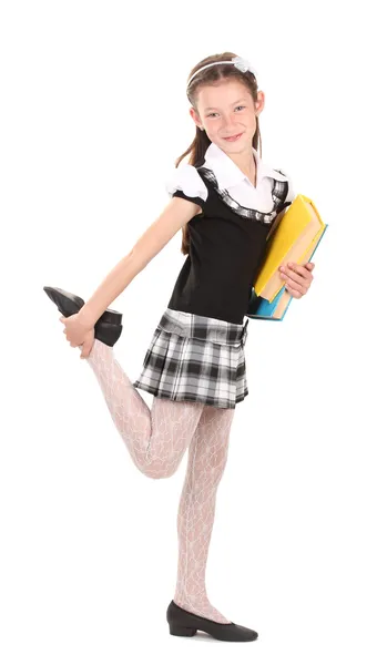 Vacker liten flicka i skoluniform med böcker isolerad på vit — Stockfoto