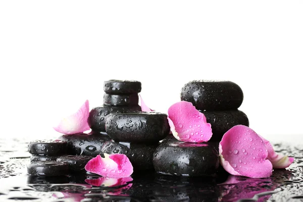 Pietre termali con gocce e petali di rosa su sfondo bianco — Foto Stock