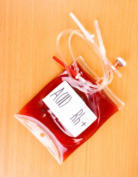 Bag of blood and infusion on wooden background — Stock Photo, Image