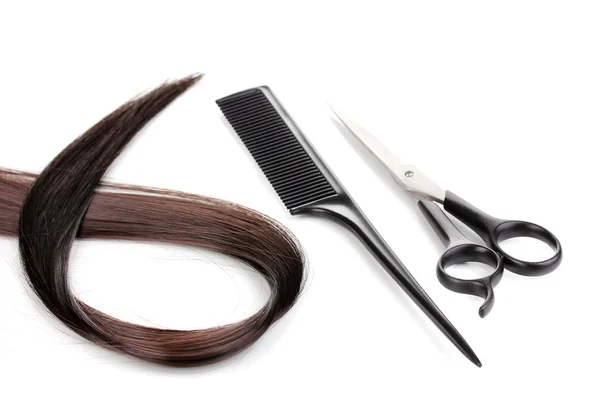 Cabelo castanho brilhante com tesouras de corte de cabelo e pente isolado em branco — Fotografia de Stock