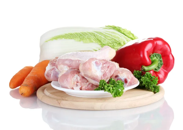 Verduras frescas con palitos de pollo crudos y filete de cerdo en la tabla de cortar aislado en blanco —  Fotos de Stock
