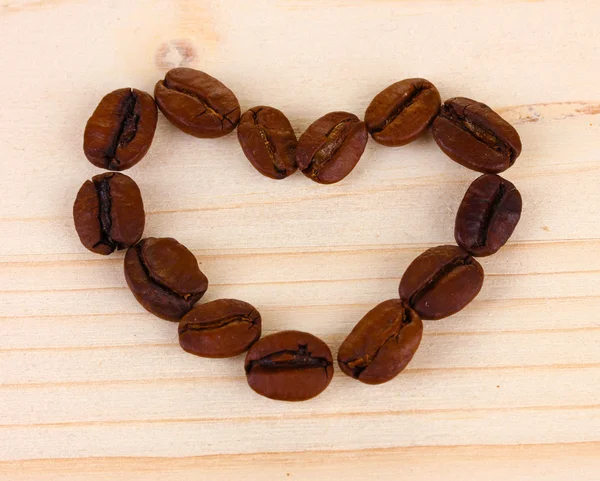 Coeur de grains de café sur fond en bois — Photo