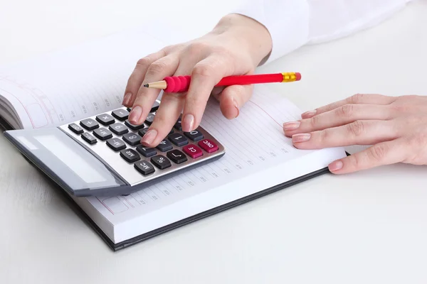 Женщина руки с карандашом, ноутбук и калькулятор изолированы на белом — стоковое фото