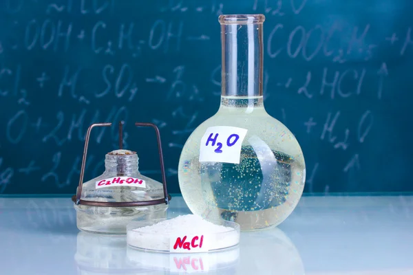 Tubos de ensaio com vários ácidos e outros produtos químicos no fundo do quadro negro — Fotografia de Stock