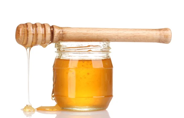 Sklenice medu a dřevěné mrholení izolované na bílém — Stock fotografie