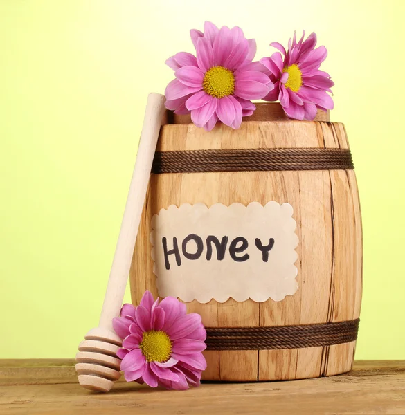 Süßer Honig im Fass mit Nieselregen auf Holztisch auf grünem Hintergrund — Stockfoto