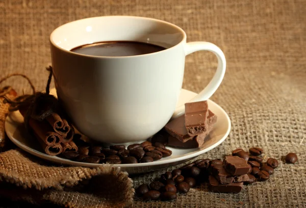 Tasse de café, haricots et chocolat sur fond de sac — Photo