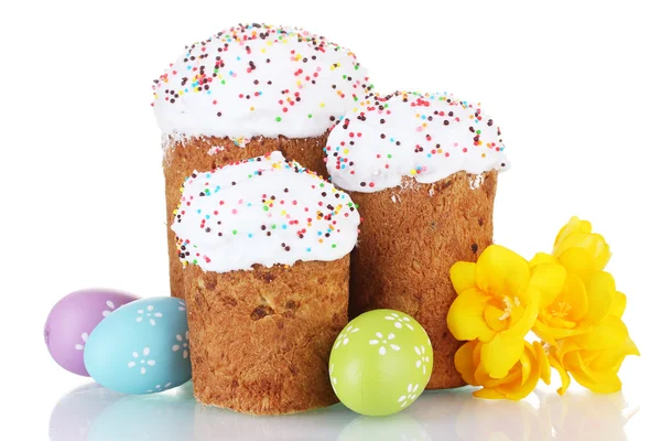 Mooie Pasen cakes, kleurrijke eieren en bloemen geïsoleerd op wit — Stockfoto