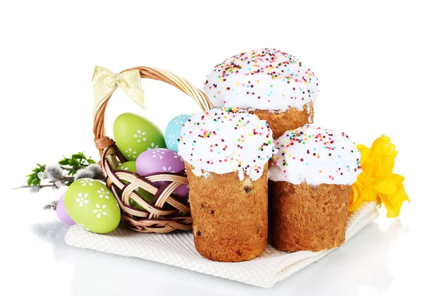 Piękne wielkanocne ciasta, kolorowe jajka w koszyku i kwiaty na białym tle — Zdjęcie stockowe