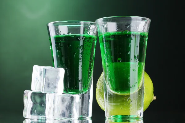 Dwie szklanki absyntu, lipa i lód na zielonym tle — Zdjęcie stockowe