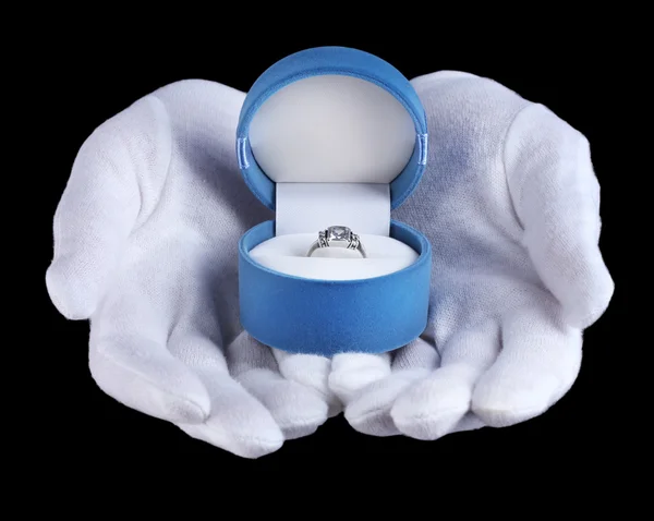 Руки, держащие кольцо в коробке на черном фоне — стоковое фото