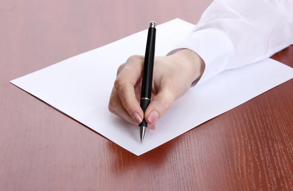 Nő kézzel írt papíron, a fából készült asztal — Stock Fotó