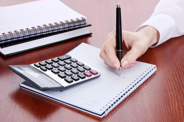 Nők kezében ceruza, jegyzetfüzet, számológép, a fából készült asztal — Stock Fotó