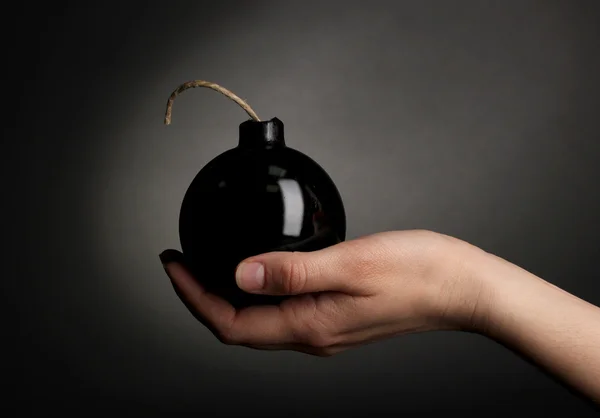 Bomba in stile cartone animato in mano su sfondo nero — Foto Stock