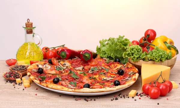 Delicious pizza and vegetables on wooden table — Stock Photo, Image