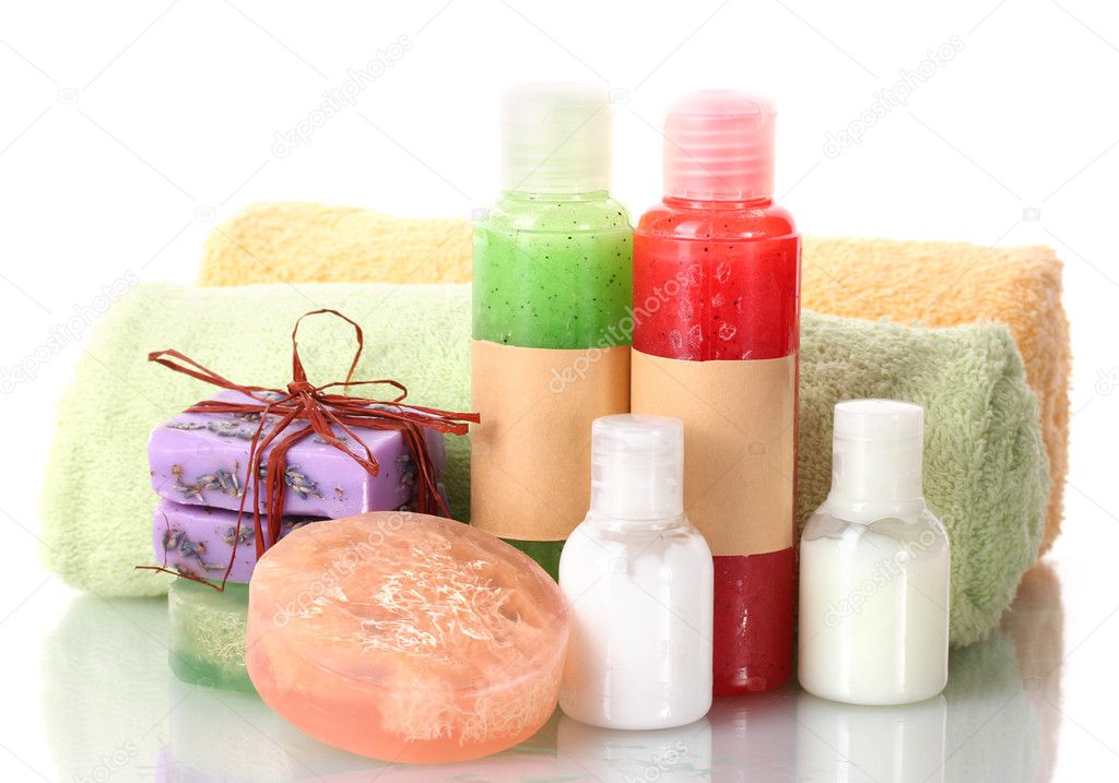Bottles with scrub, soaps and towels isolated on white