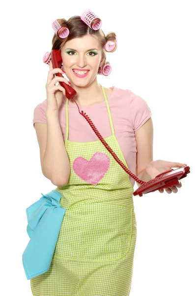 Mooie jonge huisvrouw met rode telefoon geïsoleerd op wit — Stockfoto