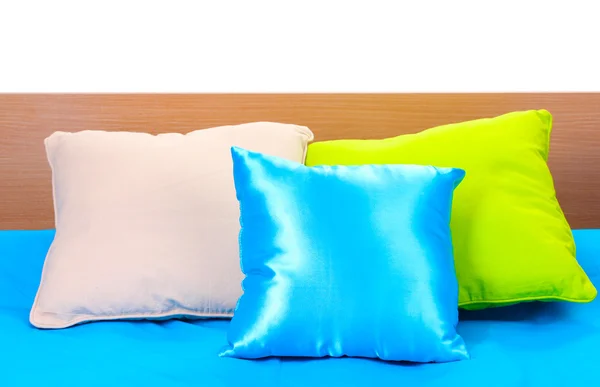 Яскраві подушки на ліжку на білому тлі — стокове фото