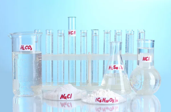 Test tüpleri çeşitli asitler ve mavi zemin üzerine kimyasal madde ile — Stok fotoğraf