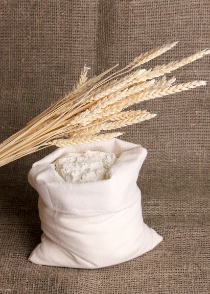 Зерно муки и пшеницы на мешковине — стоковое фото