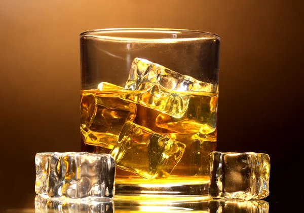 Glas whiskey och is på brun bakgrund — Stockfoto