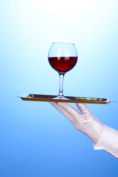 Hand in Hand mit Silbertablett mit Weinglas auf blauem Hintergrund — Stockfoto