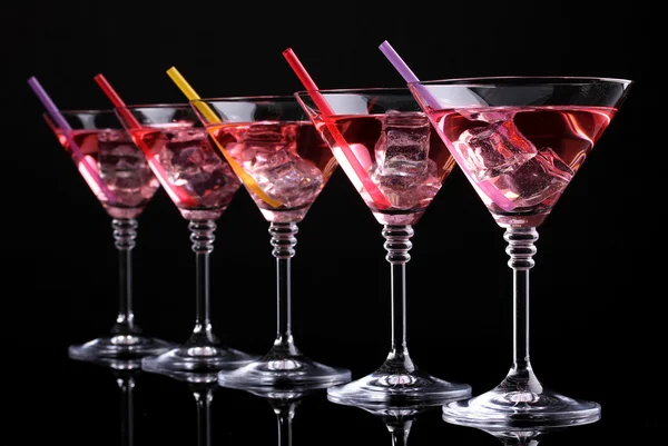 Cocktail rouge dans des verres à martini isolés sur noir — Photo