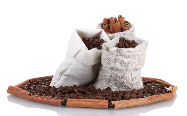 Kávová zrna a skořice v plátno pytle izolované na bílém — Stock fotografie