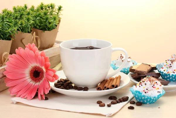Taza de café y gerberas, palitos de canela en la mesa de madera —  Fotos de Stock