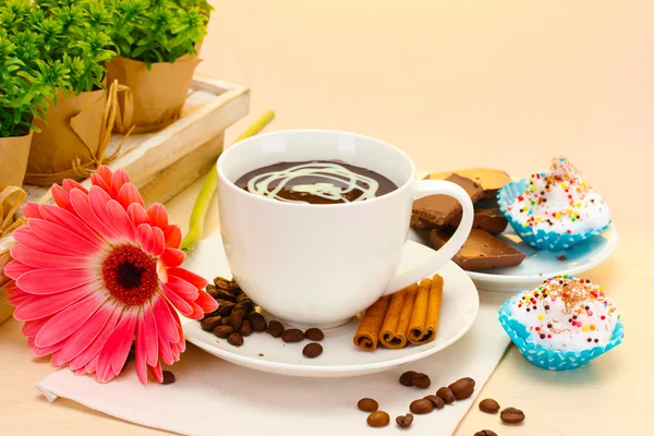 Kopp kaffe och gerbera bönor, kanel pinnar på träbord — Stockfoto