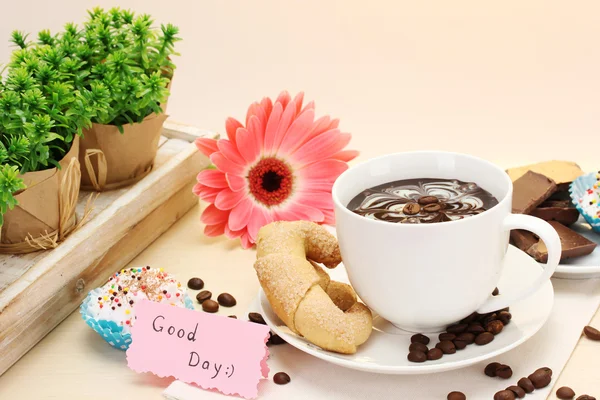 Xícara de café e feijão gerbera, paus de canela na mesa de madeira — Fotografia de Stock