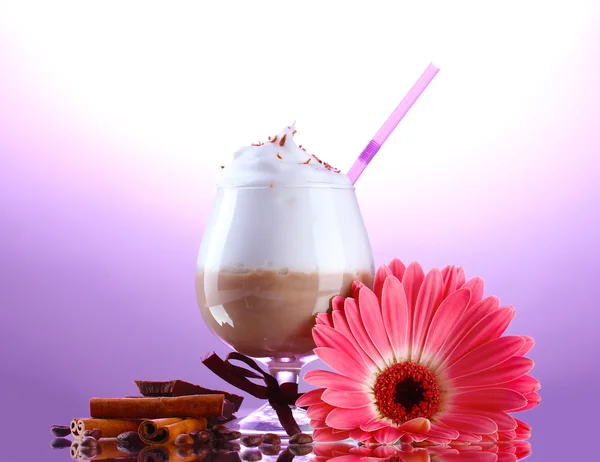 Glass of coffee cocktail and gerbera flower on purple background — Stock Photo, Image