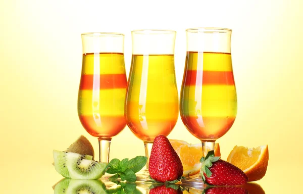 Gelatina de frutas en vasos y frutas sobre fondo amarillo — Foto de Stock