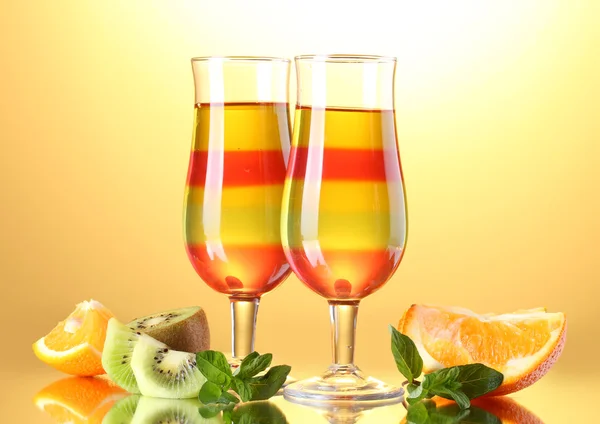 Gelatina di frutta in bicchieri e frutta su sfondo giallo — Foto Stock