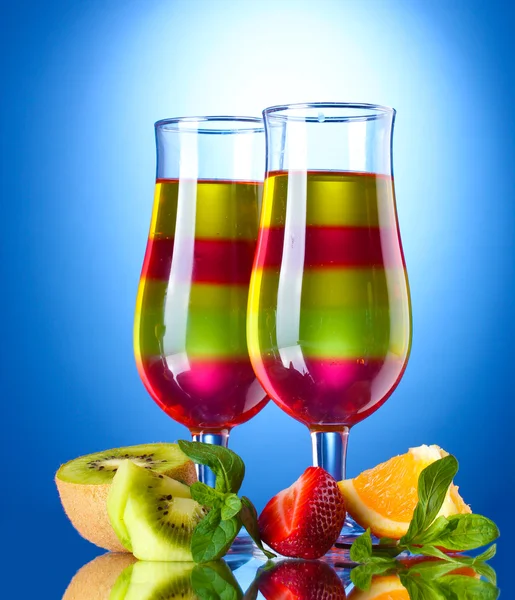 Fruit jelly in glasses and fruits on blue background — Stock Photo, Image