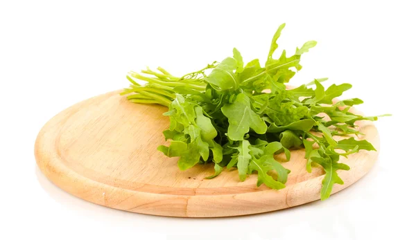 Fresh rucola salad or rocket lettuce leaves on wooden board isolated on white — Stock Photo, Image