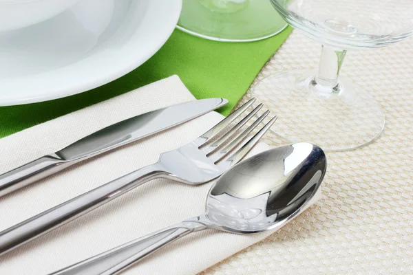 Apparecchiatura della tavola con forchetta, coltello, cucchiaio, piatti e tovagliolo — Foto Stock