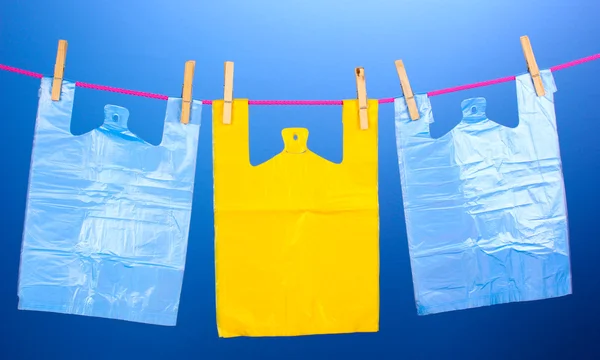 Целофановые мешки висят на веревке на синем фоне — стоковое фото