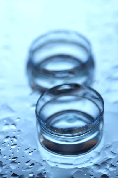 Lente de contato com gotas no fundo azul — Fotografia de Stock