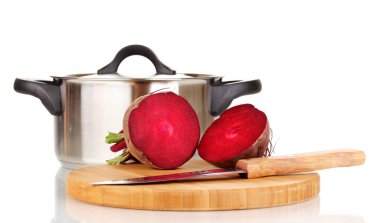 Young red beet on wooden board and pan isolated on white clipart