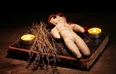 Voodoo doll girl on a wooden table in the candlelight clipart