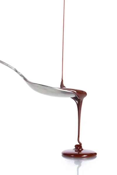 Cioccolato rosso versato in un cucchiaio isolato su bianco — Foto Stock