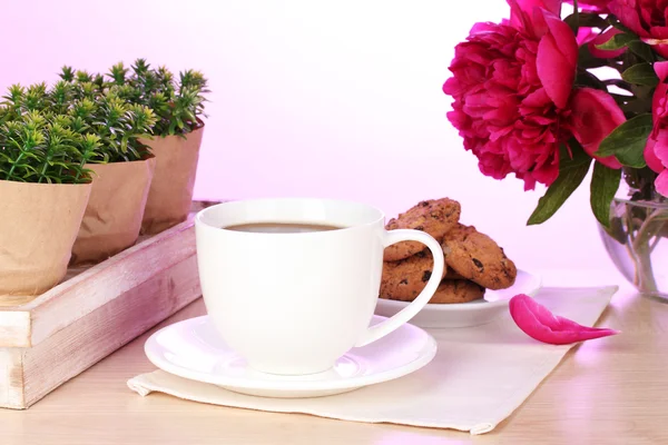 Taza de café, galletas y flores en la mesa en la cafetería —  Fotos de Stock