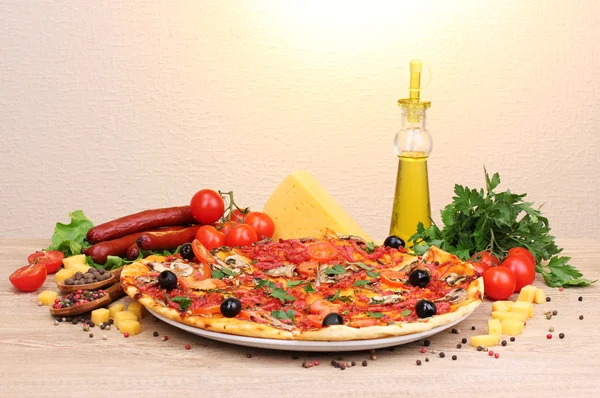 stock image Delicious pizza, vegetables and salami on wooden table